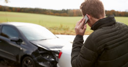 driver calling his insurance company after a car accident