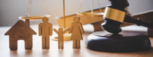 judge's gavel, cutouts of a family, and home, justice scales