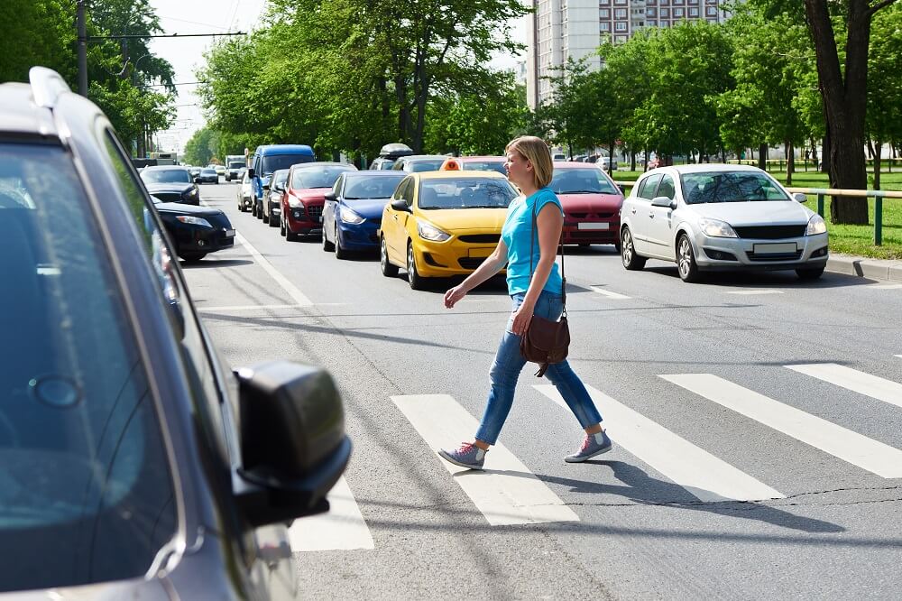 Lady pedestrian crossing the street.