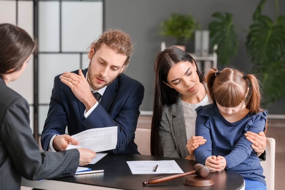 Young couple and their daughter visiting child custody lawyer in office.