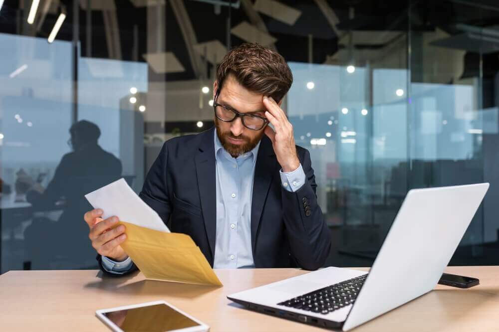 Problematic man reading demand letter.