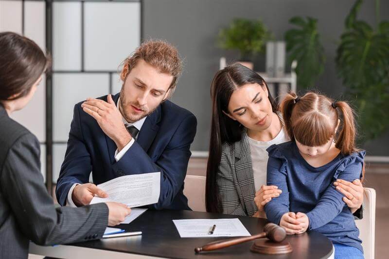 Young couple and their daughter visiting divorce lawyer in office.