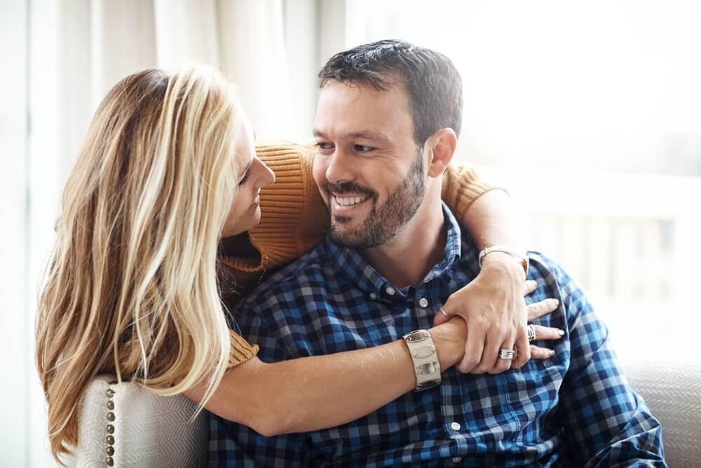 Happy couple together in their cozy living room.